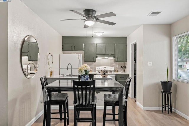 dining area featuring light hardwood / wood-style flooring, ceiling fan, and sink