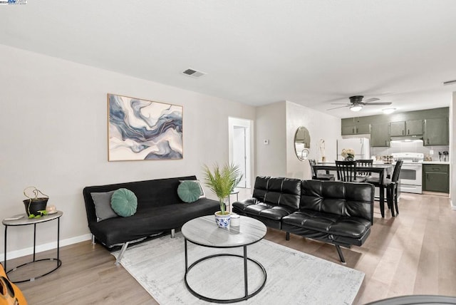 living room featuring ceiling fan and light hardwood / wood-style flooring