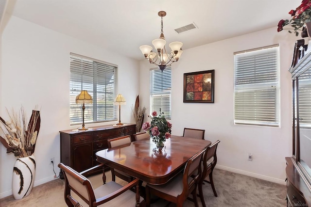 carpeted dining room with a chandelier