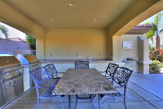 view of patio with a grill, exterior kitchen, and sink