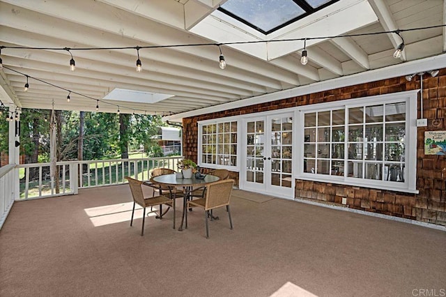 sunroom / solarium featuring a skylight and french doors