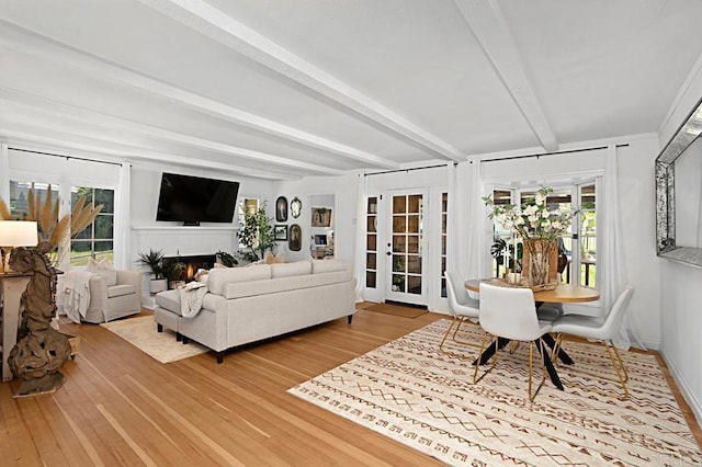 living room featuring hardwood / wood-style flooring, beam ceiling, and a wealth of natural light