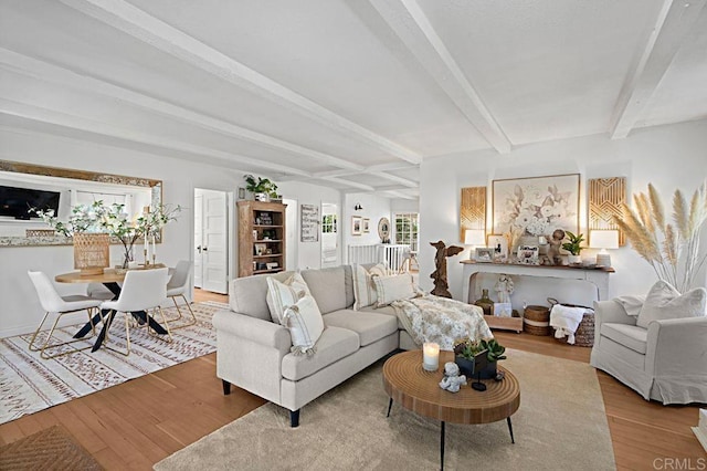 living room with beam ceiling and light hardwood / wood-style floors