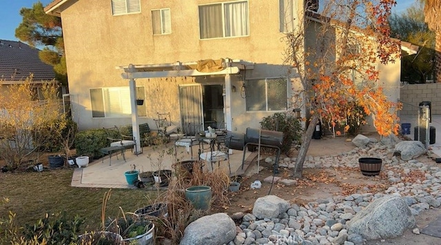 rear view of house featuring a pergola and a patio area