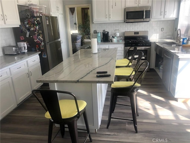 kitchen featuring white cabinets, light stone countertops, and stainless steel appliances