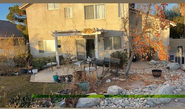 rear view of house with a pergola and a patio