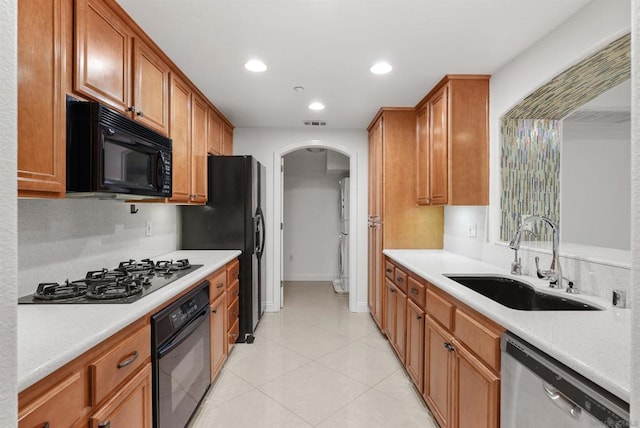 kitchen featuring light tile patterned flooring, sink, and black appliances