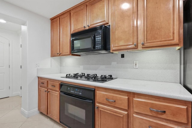 kitchen with light tile patterned flooring, decorative backsplash, light stone countertops, and black appliances