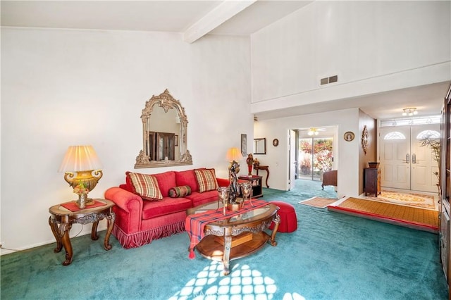 carpeted living room featuring beamed ceiling and a high ceiling