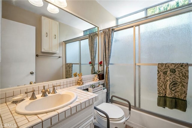 full bathroom featuring toilet, vanity, and combined bath / shower with glass door