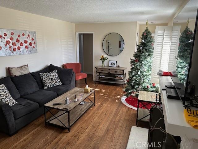 living room featuring dark hardwood / wood-style flooring and a textured ceiling