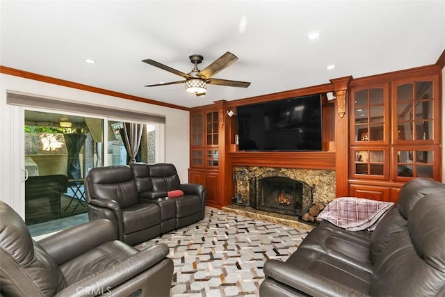 living room with ornamental molding, ceiling fan, and a premium fireplace