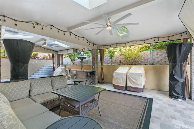 view of patio featuring an outdoor living space, ceiling fan, and a bar