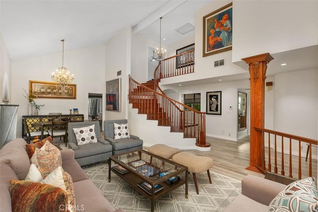 living room featuring high vaulted ceiling, an inviting chandelier, hardwood / wood-style flooring, ornate columns, and beamed ceiling