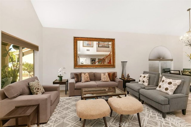 living room featuring a chandelier and lofted ceiling