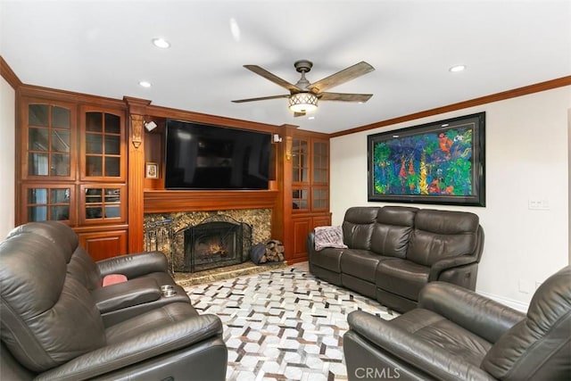 living room featuring ceiling fan, ornamental molding, and a premium fireplace