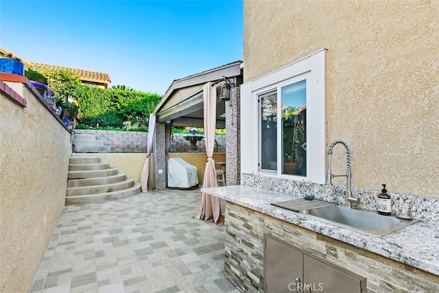 view of patio featuring exterior kitchen and an outdoor wet bar