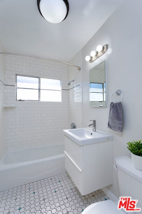 full bathroom featuring vanity, toilet, and tiled shower / bath