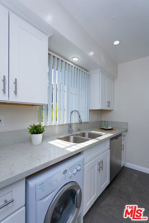 kitchen featuring white cabinets, dishwasher, sink, and washer / clothes dryer