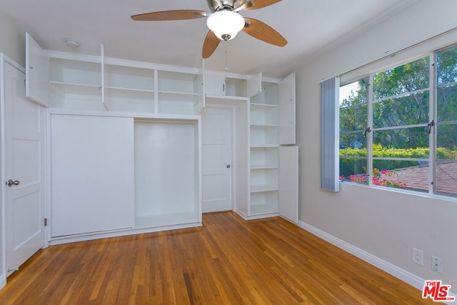 unfurnished bedroom with ceiling fan, a closet, and wood-type flooring