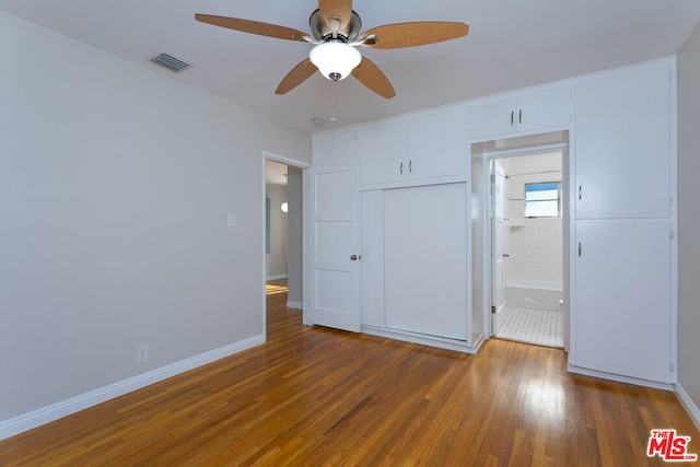 unfurnished bedroom with ceiling fan, a closet, and dark wood-type flooring