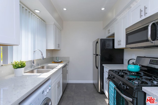 kitchen featuring washer / clothes dryer, white cabinetry, sink, and appliances with stainless steel finishes