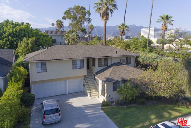 view of front of property featuring a mountain view, a garage, and a front lawn