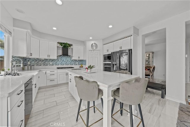 kitchen featuring white cabinets, stainless steel appliances, and a center island