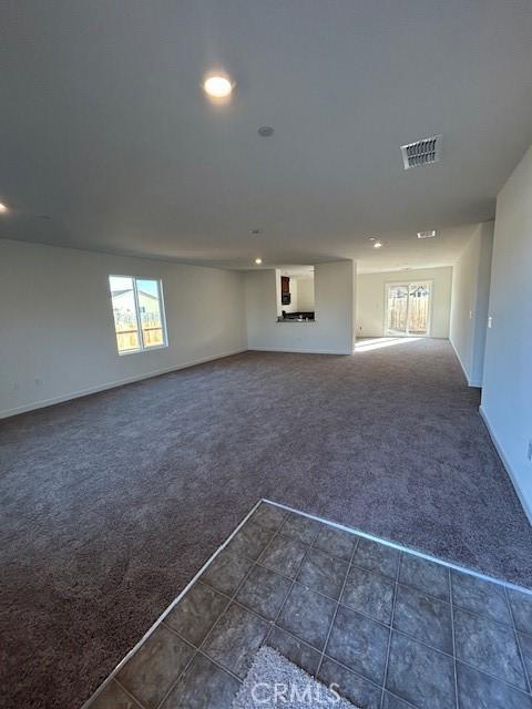 unfurnished living room with dark colored carpet