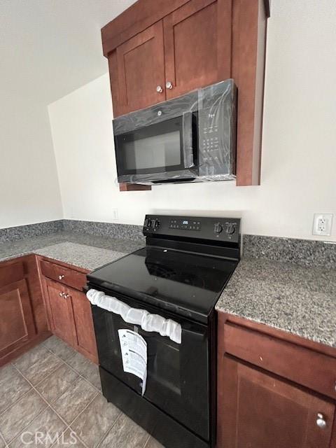 kitchen with dark stone countertops and black appliances