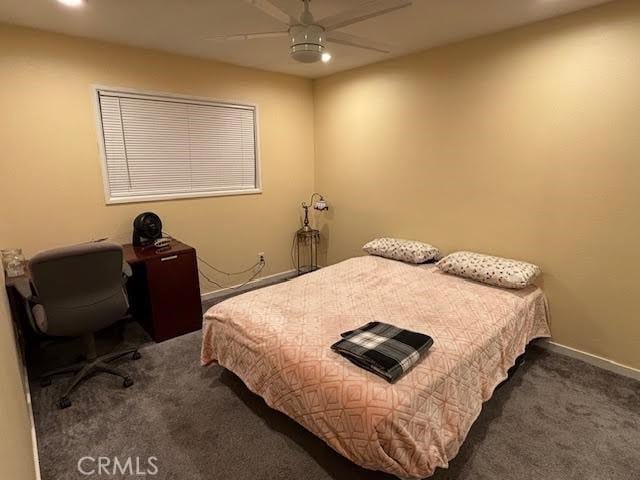 bedroom with ceiling fan and dark carpet