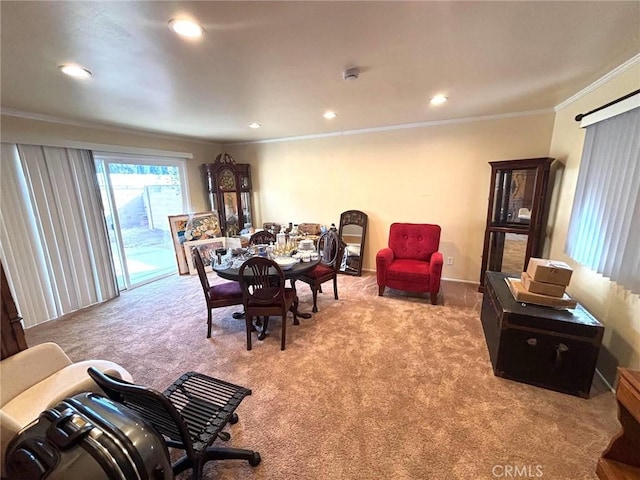 carpeted dining room with ornamental molding