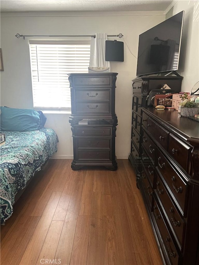 bedroom featuring wood-type flooring and crown molding