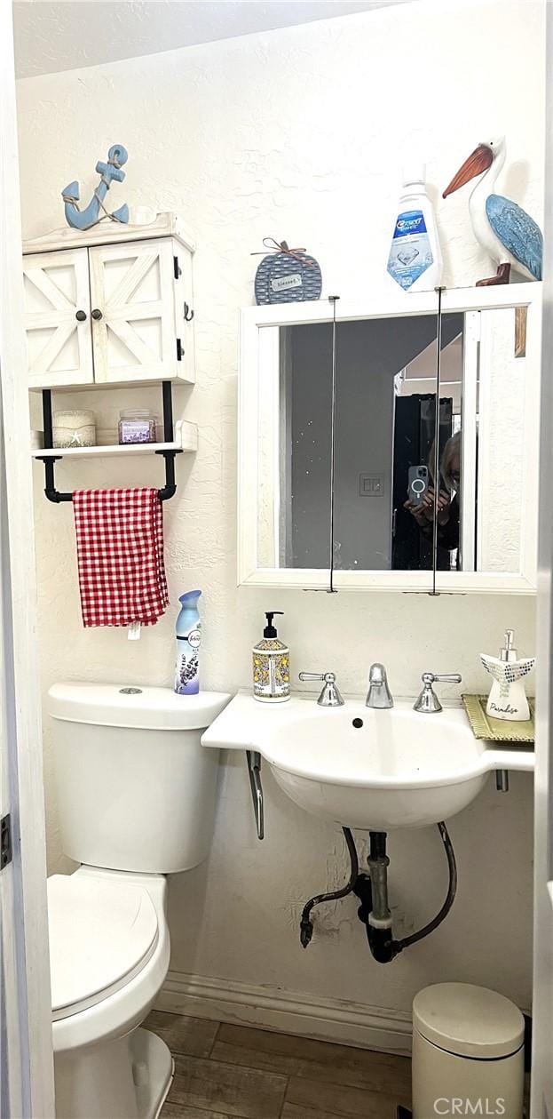 bathroom featuring hardwood / wood-style floors, toilet, and sink