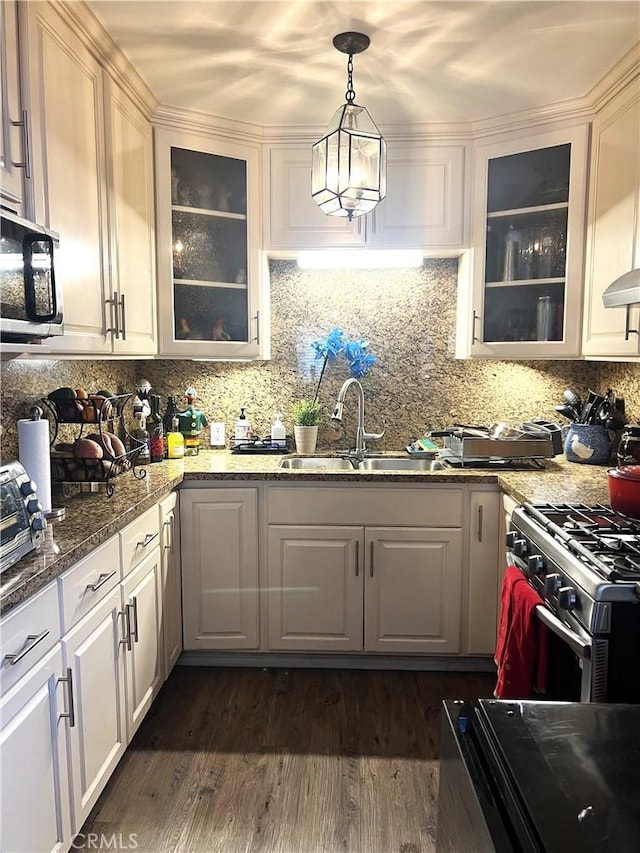 kitchen featuring high end range, dark hardwood / wood-style flooring, dark stone counters, sink, and white cabinetry