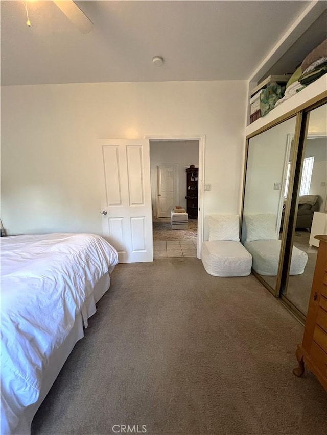 carpeted bedroom with a closet and ceiling fan