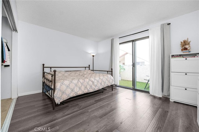 bedroom featuring dark wood-type flooring, access to outside, and a textured ceiling