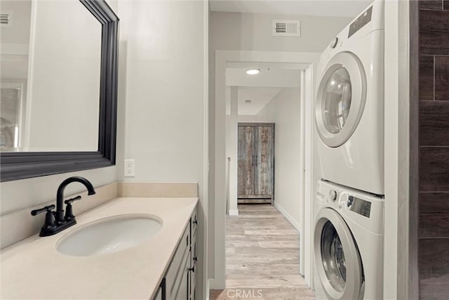 interior space with hardwood / wood-style floors, vanity, and stacked washer / drying machine