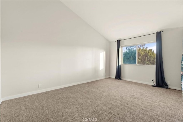 spare room with carpet and vaulted ceiling