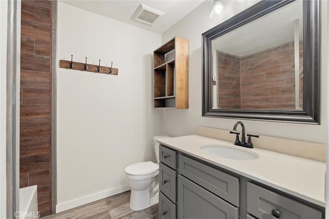 bathroom featuring vanity, wood-type flooring, and toilet