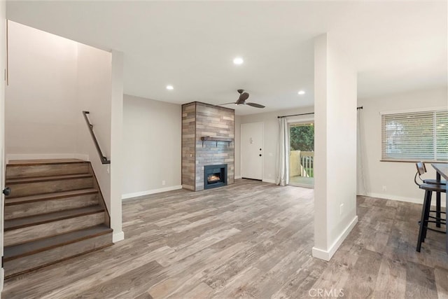 unfurnished living room featuring ceiling fan, a tile fireplace, and light hardwood / wood-style flooring