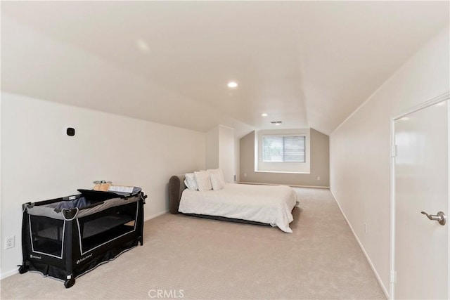 bedroom with light colored carpet and lofted ceiling