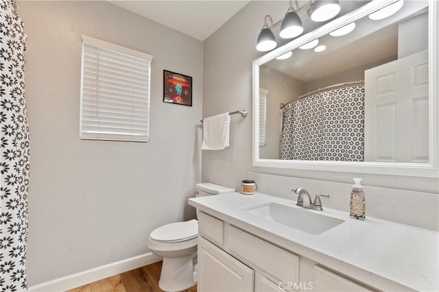 bathroom with a shower with curtain, vanity, toilet, and wood-type flooring