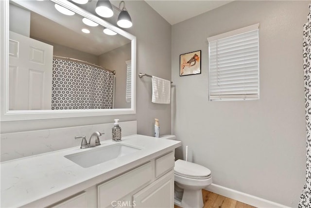 bathroom with a shower with shower curtain, vanity, hardwood / wood-style flooring, and toilet