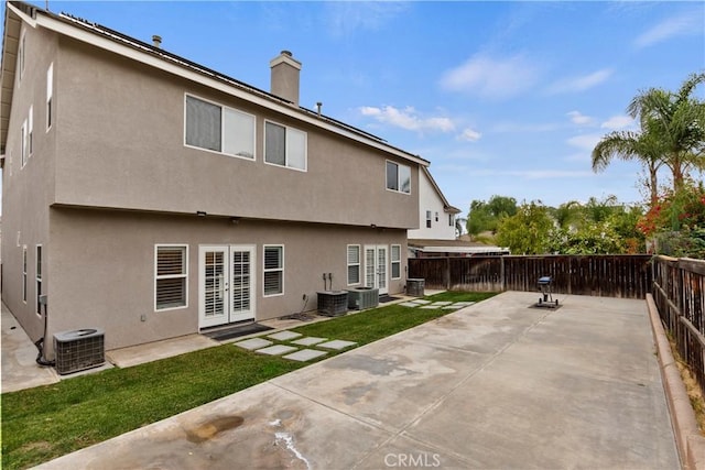 back of house with french doors, a yard, cooling unit, and a patio area