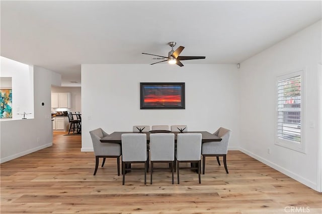 dining space with ceiling fan and light hardwood / wood-style floors