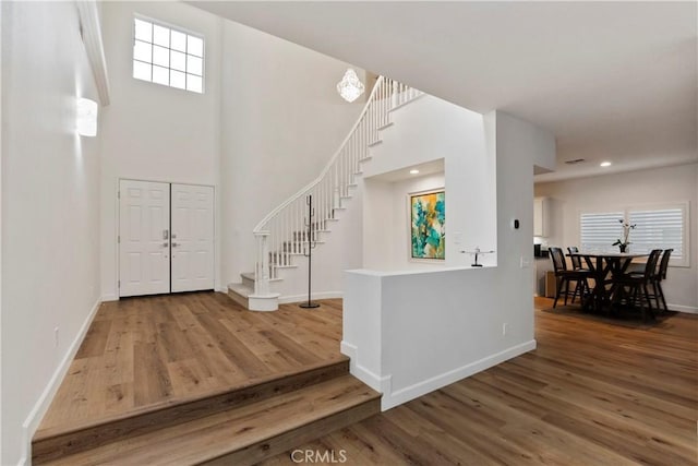 foyer featuring wood-type flooring and a high ceiling