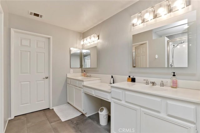 bathroom with a shower, tile patterned flooring, and vanity