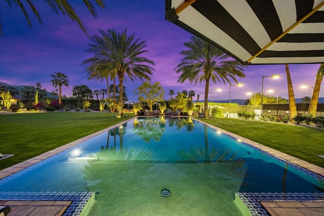 pool at dusk with a lawn