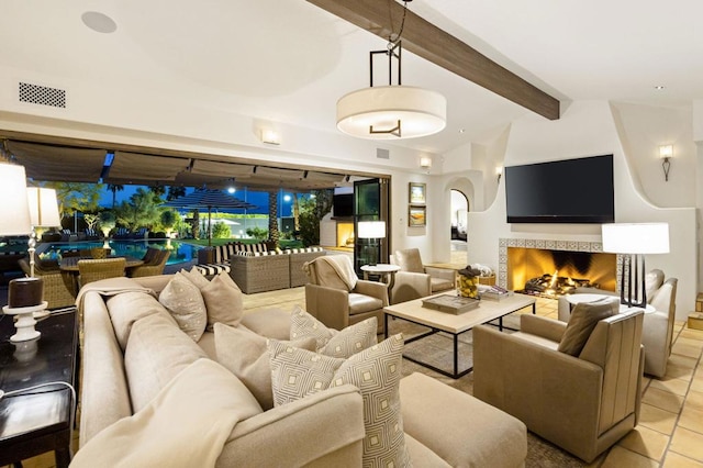 interior space featuring a fireplace, lofted ceiling with beams, and light tile patterned flooring